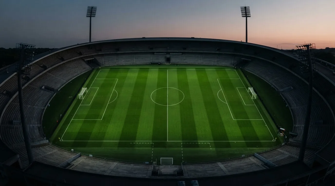 Ein Fußballplatz am Abend aus der Vogelperspektive, Flutlichtmasten ausgeschaltet, die Rasenlinien deutlich sichtbar.