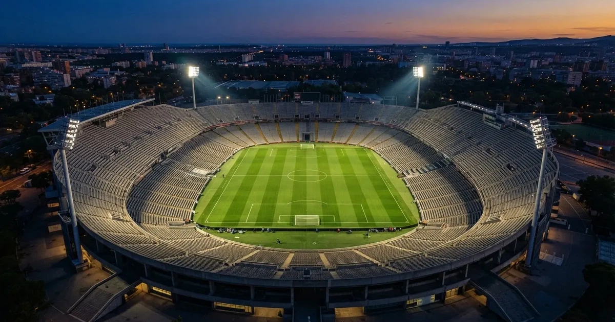 Ein riesiges Stadion in der Abenddämmerung aus der Vogelperspektive gesehen, die Lichter an den Rängen sind eingeschaltet.